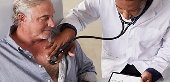 A doctor holding a 3M™ Littmann® CORE Digital Stethoscope up to a patient's chest.
