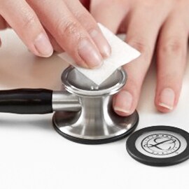 Proper cleaning of the open bell of a Littmann stethoscope using an alcohol wipe.