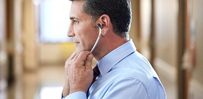 Doctor correctly putting on Littmann stethoscope with eartips facing forward.
