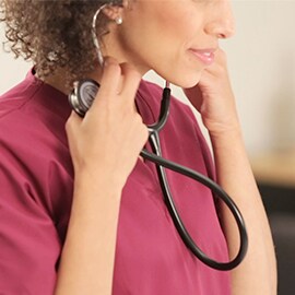Nurse putting the eartips of her 3M Littmann Classic III Stethoscope into her ears.